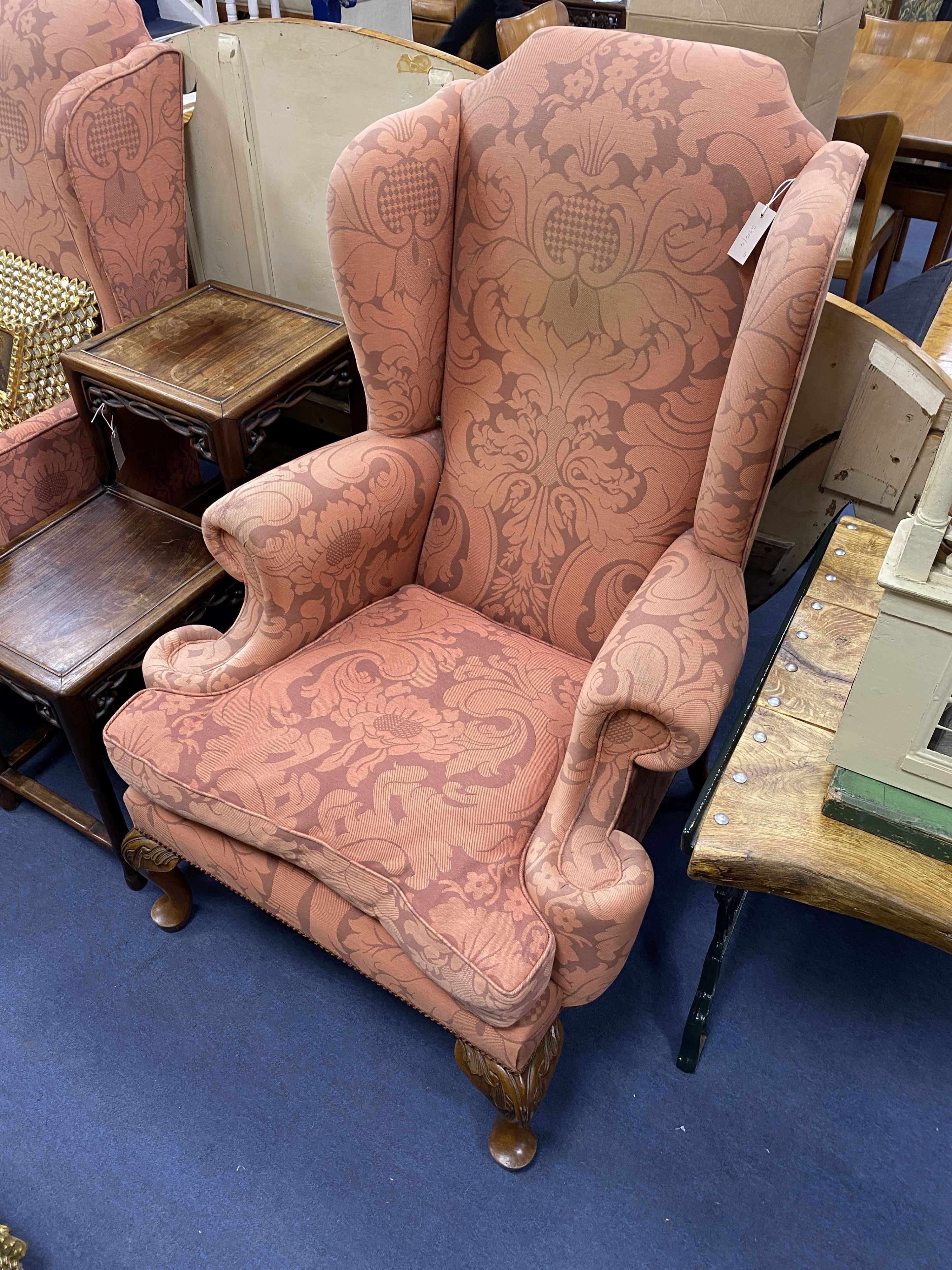 A pair of George I style upholstered wing armchairs on acanthus carved oak feet, width 82cm, depth 86cm, height 124cm